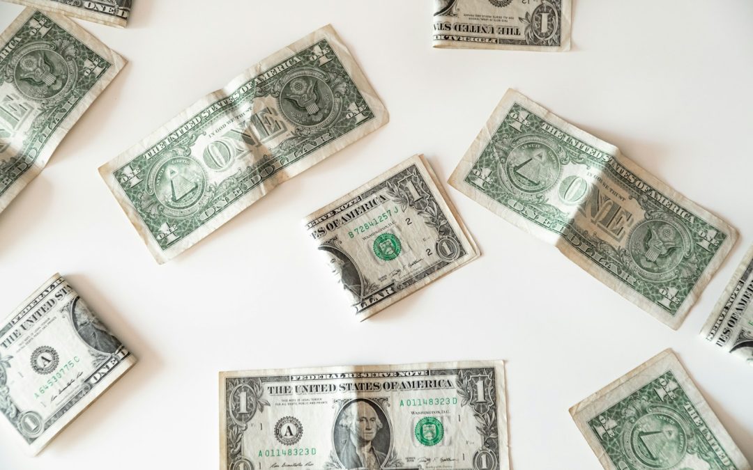 One dollar bills scattered on a white background